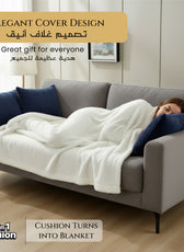 Woman lying on a gray sofa with a 2 in 1 white blanket and blue cushions, in a room with light-colored walls and wooden floor.