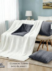 White blanket with gray cushion and pillow on a chair in a room setting.